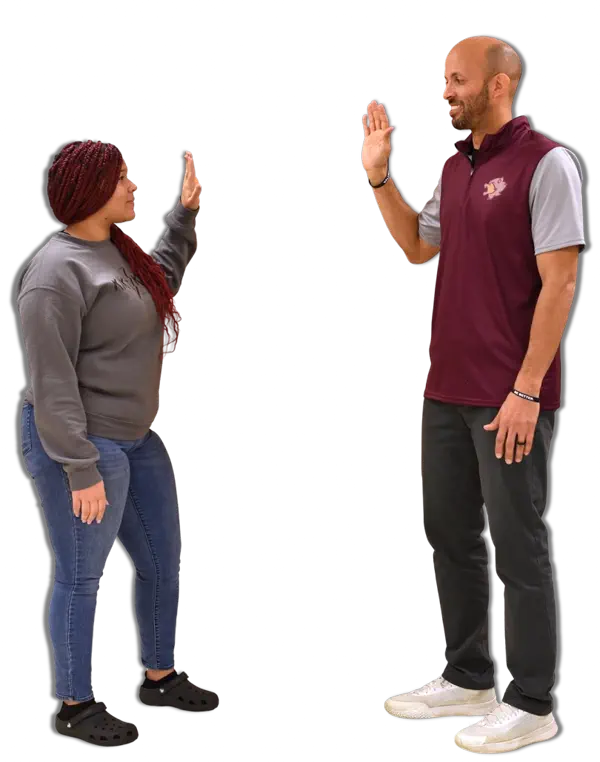 Male student wearing a backpack and holding a thumbs up