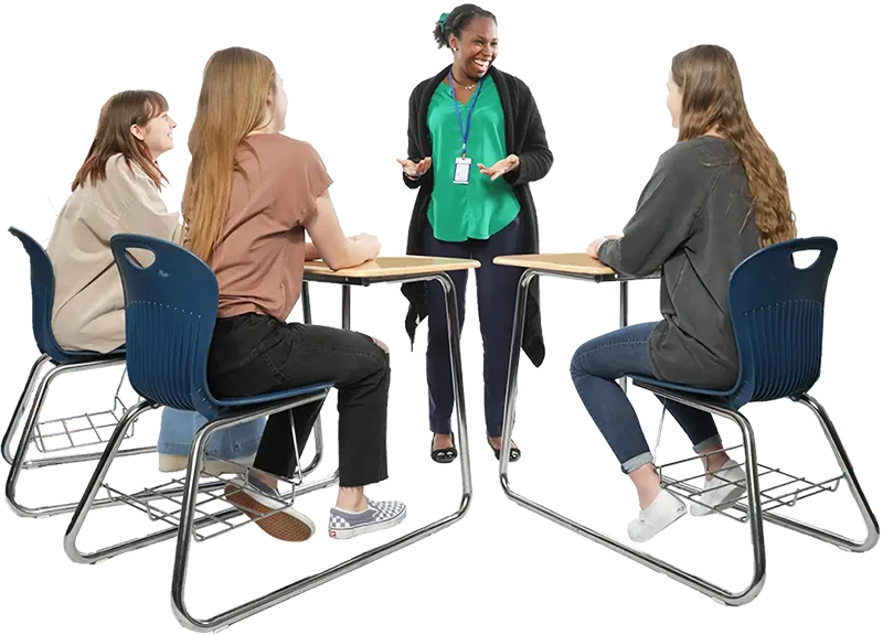 Teacher standing and talking to three students at their desks